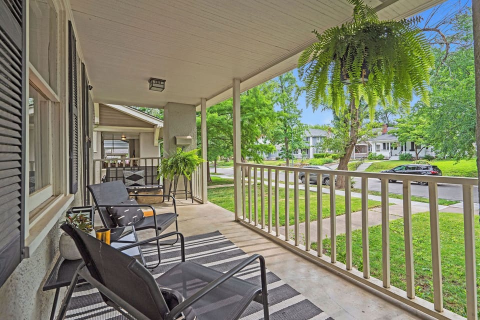 Spacious covered porch with multiple seating areas, providing the ideal outdoor hangout in any season during your Kansas City getaway.