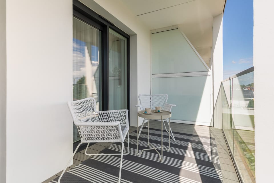Another view of the balcony, emphasizing its relaxing atmosphere and inviting furniture for outdoor leisure.

