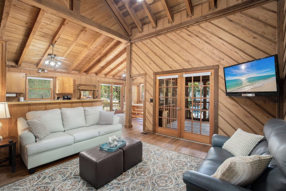 Relax in your rustic retreat with vaulted wood ceilings, plush seating, and modern TV for cozy evenings after exploring.