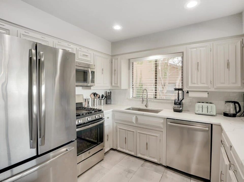 Featuring quartz countertops, stainless steel appliances, and gorgeous stone flooring, this kitchen is as polished as they come!