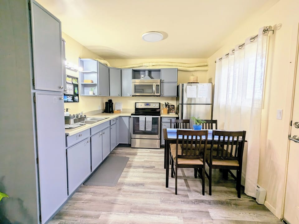 Fully equipped kitchen with dining for four, opening to living room.