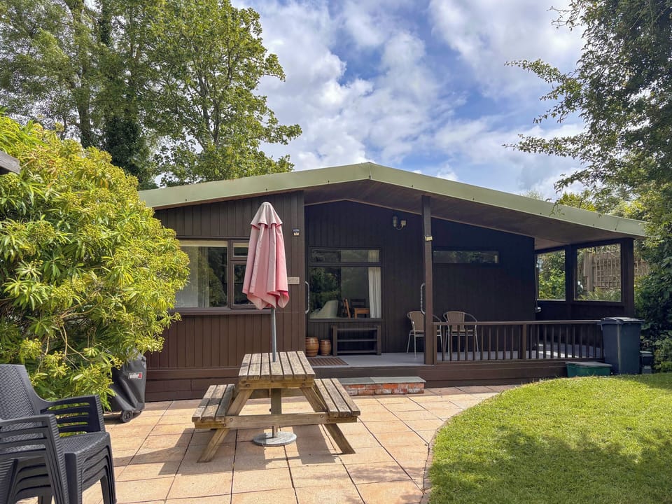 A view of the Lodge, showing the patio area, ideal for outdoor dining and barbecue! A lovely place to catch the evening sun after a busy day. | The Lodge, Hayle