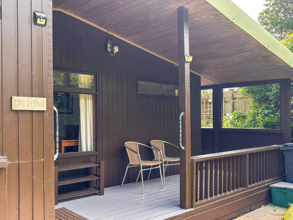 The Lodge has a sheltered veranda area with decking. The perfect place to relax with a book and a cuppa. | The Lodge, Hayle