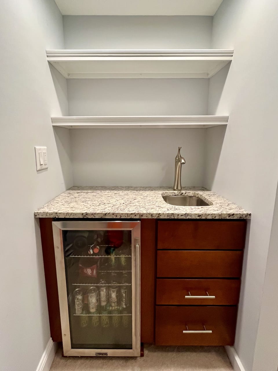 Ground floor wet bar including refrigerator for beverages and sink.