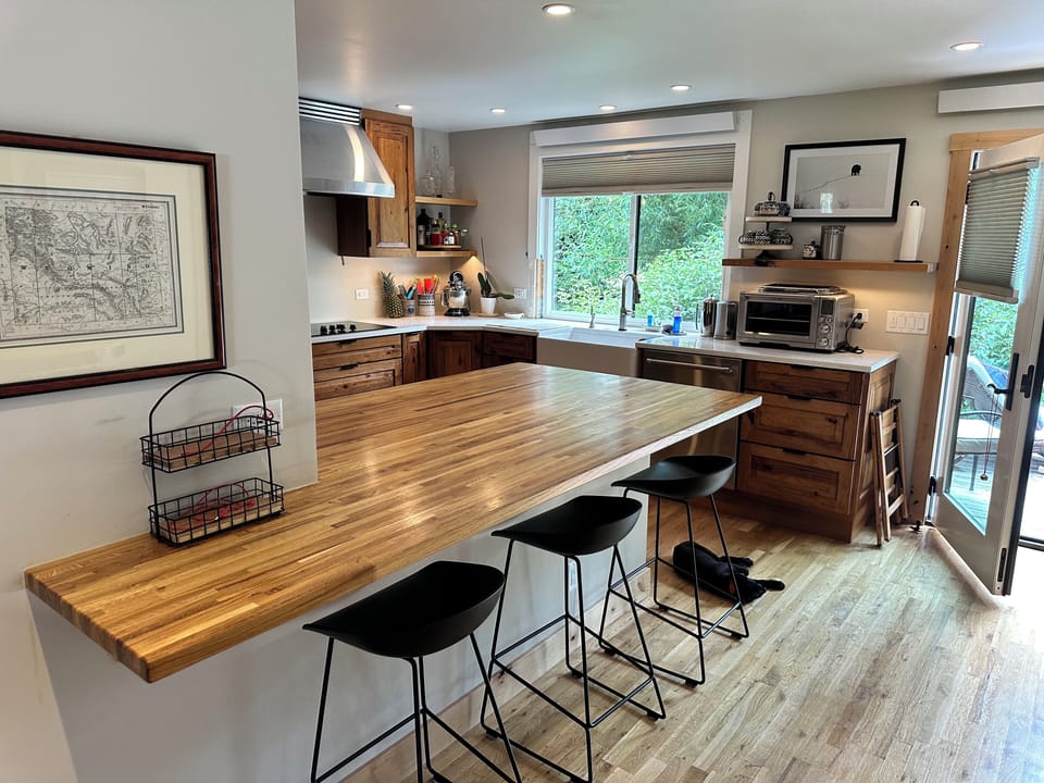 Open Kitchen and countertop with 5 bar stools.