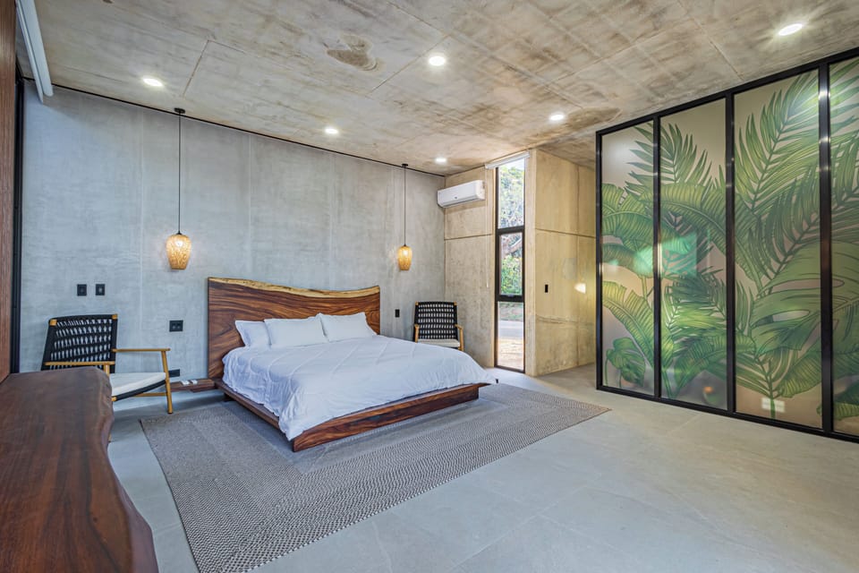 Elegant guest bedroom featuring a king-size bed, offering privacy and tranquility. Enjoy a luxurious stay in this Tamarindo beach rental, perfect for families or groups.
