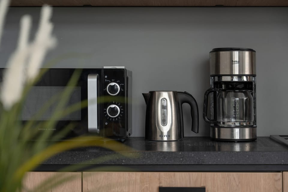 A well-equipped kitchen corner featuring a coffee machine, kettle, and toaster, providing all the essentials for guests.

