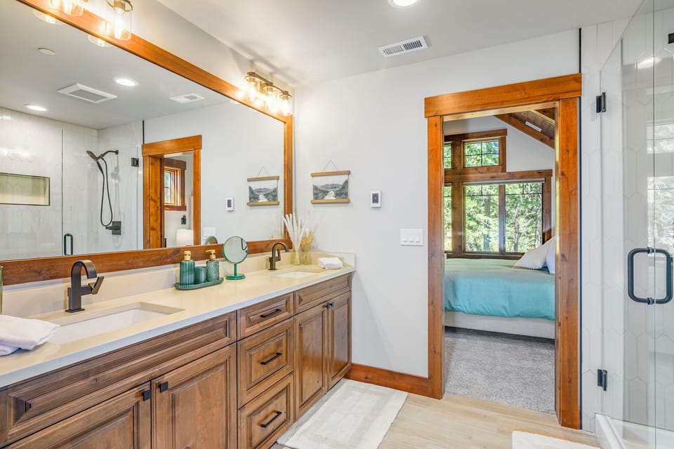 Dual-sink vanity with quartz counters and custom wood cabinetry throughout.