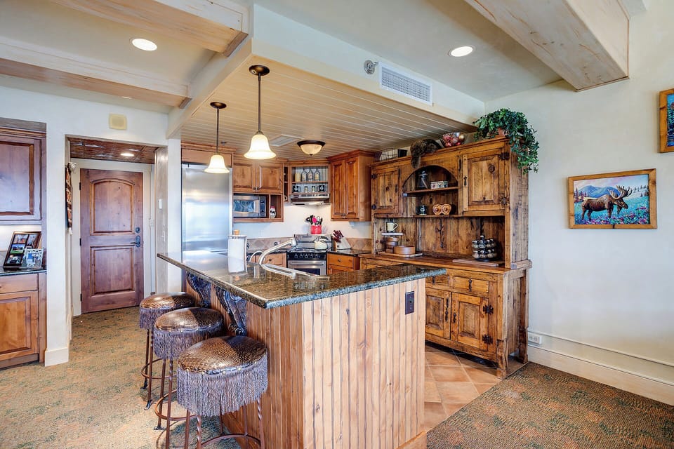 Cook in your rustic kitchen with rich wood cabinetry, granite counters, and a charming breakfast bar perfect for morning coffee.