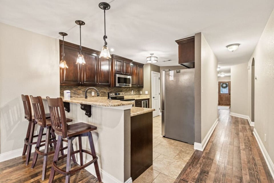 Enjoy the excitement of a fully-equipped kitchen, boasting a refrigerator, dishwasher, wine fridge, electric range and stove, Keurig coffee maker, and welcoming bar top seating with three stools.