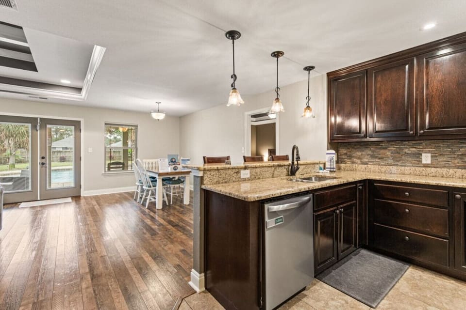 Step into the heart of the home where the open concept dining and living area flows seamlessly to the patio. A beautiful farm-style dining table seats 5, complemented by 3 additional bar top stools in the kitchen, perfect for family gatherings.
