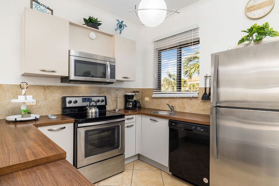 Modern kitchen complete with all necessary appliances. There is a fridge, a stove, an oven, a microwave, a coffee maker, and more.