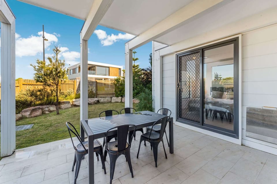 Fully fenced backyard with outdoor furniture and BBQ.