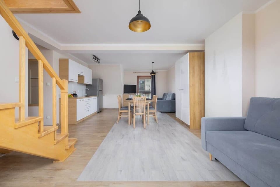 An inviting open-plan area with a wooden staircase, perfect for gathering and dining.

