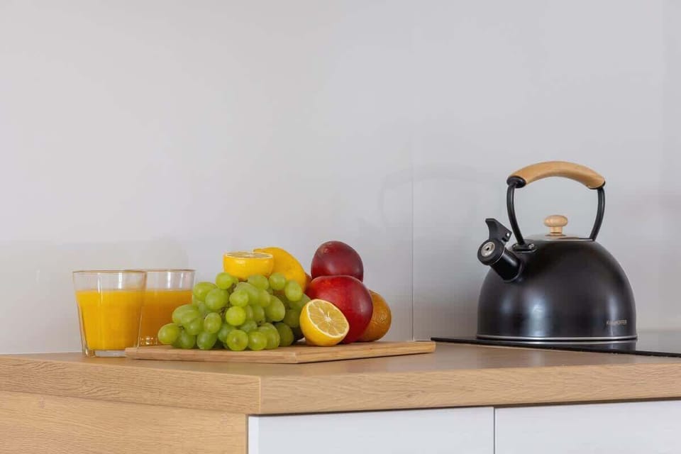 A neatly arranged countertop featuring fresh fruit and a kettle, adding a homely touch to the kitchen space.







