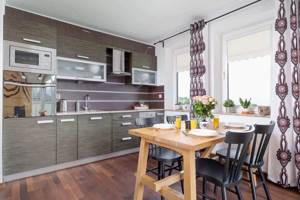 A modern kitchenette with a dining area, fully equipped for guests' cooking needs.

