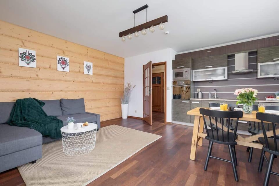 A well-lit open-plan area with a modern kitchen, dining space, and a cozy lounge.

