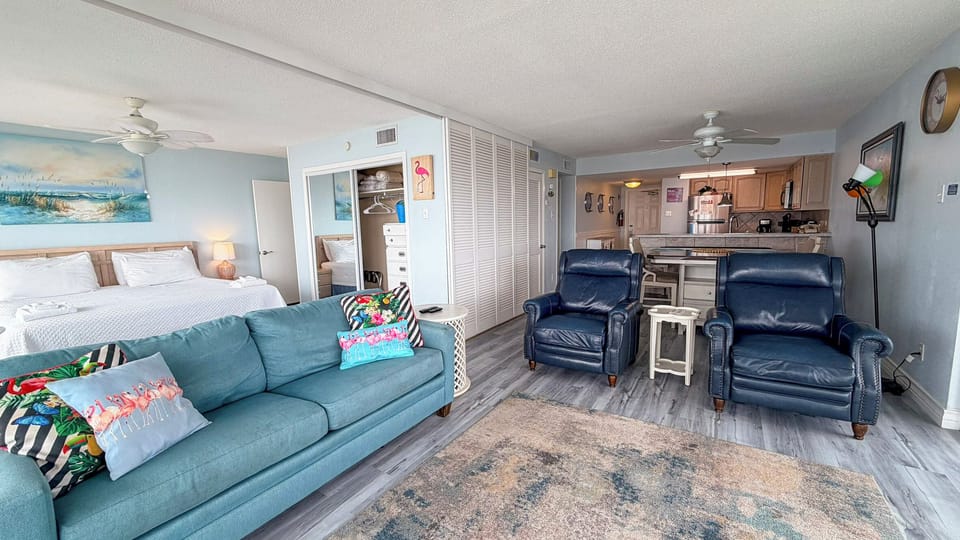 Sink into the plush sofa or recliners as soft coastal light fills this open, breezy retreat—your perfect home base for unwinding after beach days.