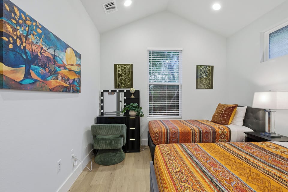 The 2nd floor guest bedroom 1 has a queen bed, a twin bed&a makeup/work station.