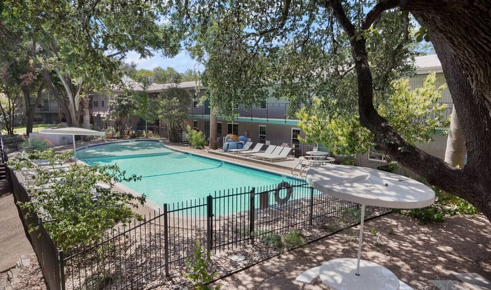 Gorgeous pool area with lounge chairs, shade, and picnic tables