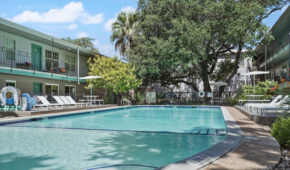 Gorgeous pool area with lounge chairs, shade, and picnic tables