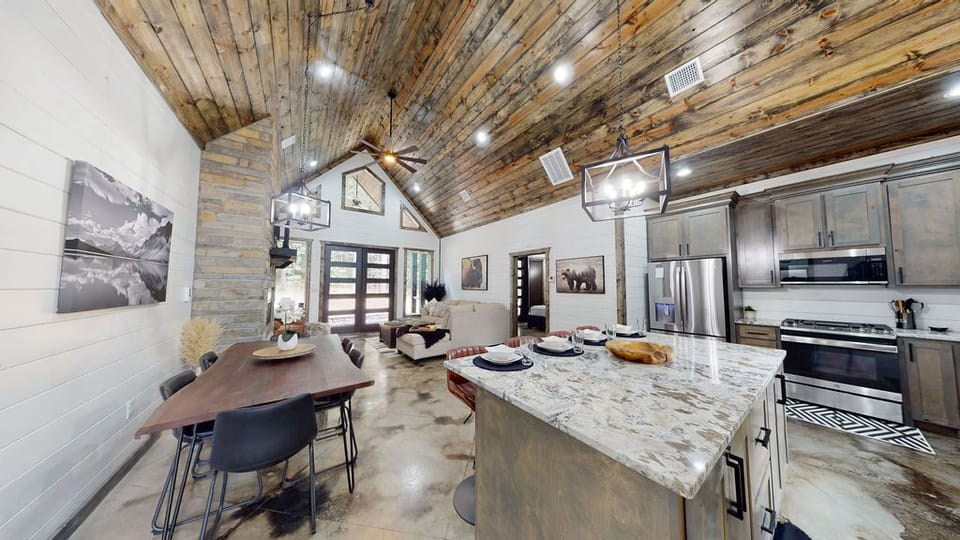 The open living room features a beautiful rocked fireplace and comfortable seating.