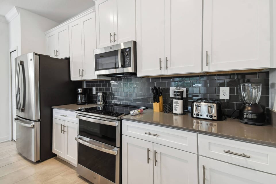 This bright kitchen combines sleek white cabinetry with dark granite countertops for a striking contrast. With stainless steel appliances and a stylish backsplash, it’s a modern space perfect for your culinary adventures.