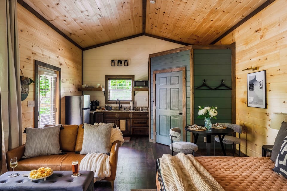 Studio cabin that offers a king-sized bed, kitchenette, dining, and living room.