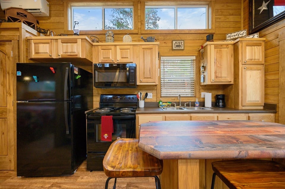 To your right is the kitchen equipped with a stove, microwave, fridge and freezer.