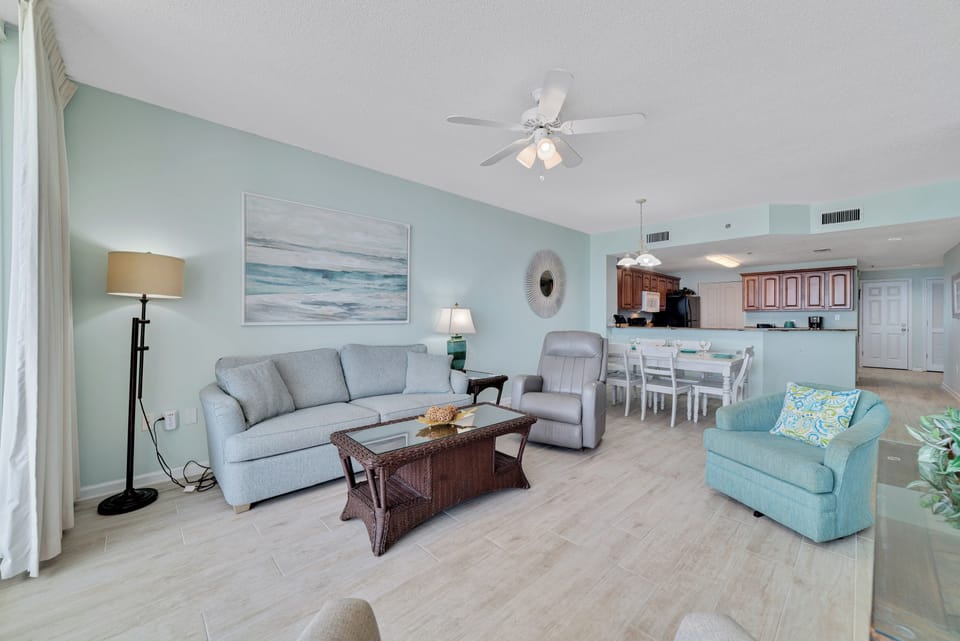 This well-appointed living space offers a comfortable sectional sofa, a round coffee table, and a dining area with seating for six, creating a welcoming atmosphere.