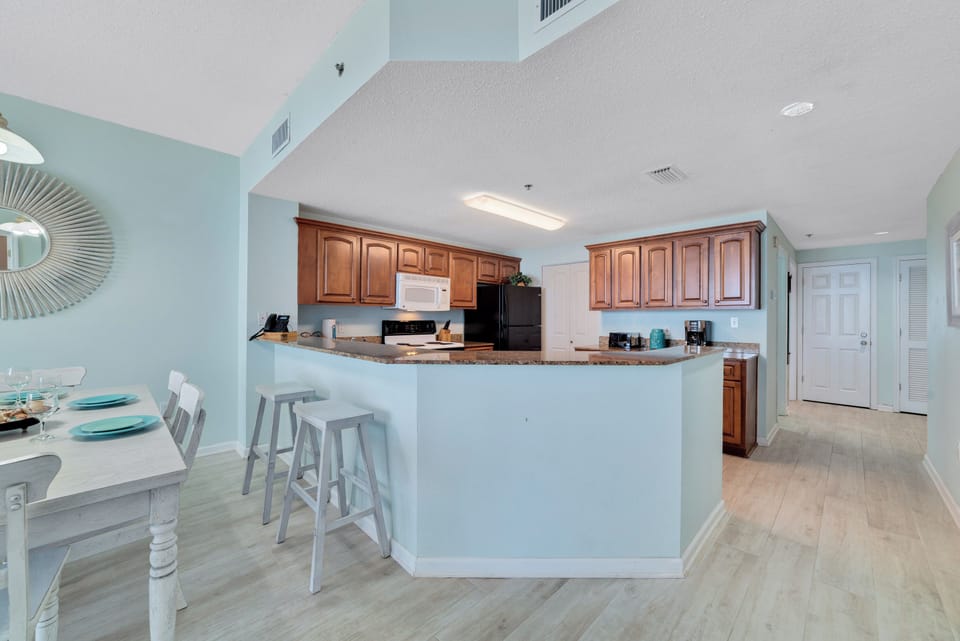 Sleek and sophisticated kitchen featuring a striking island with a stone countertop and comfortable bar stools.