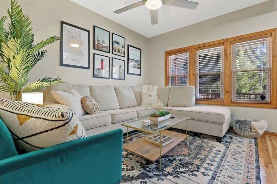 Open concept living room with comfy sectional, blankets, pillows, games, and 65" smart TV.