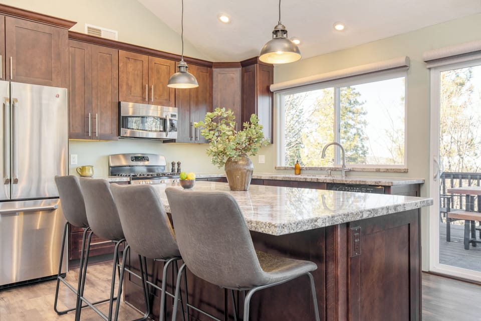 Spacious kitchen with ka gas stove, large island, and barstool seating.