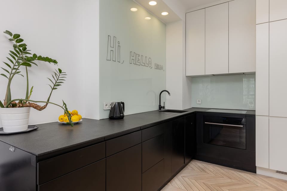 A modern kitchen with black and white cabinetry, equipped with high-quality appliances and stylish design.
