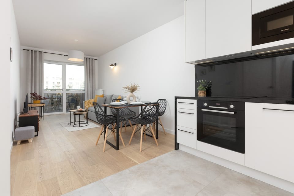 A wide-angle view of the open-plan living area and kitchen, emphasizing the bright space.

