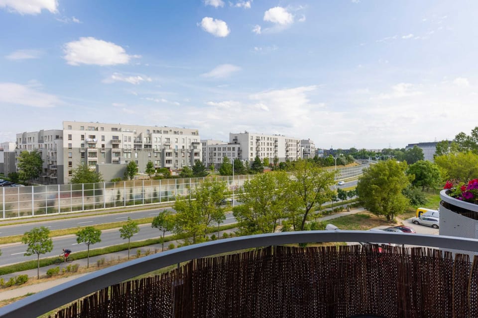 A panoramic balcony view showcasing the lush greenery and residential area.

