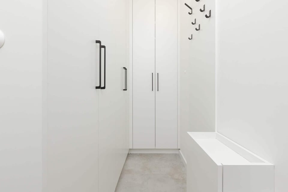 A bright and spacious hallway with built-in storage cabinets and a clean, minimalist design.

