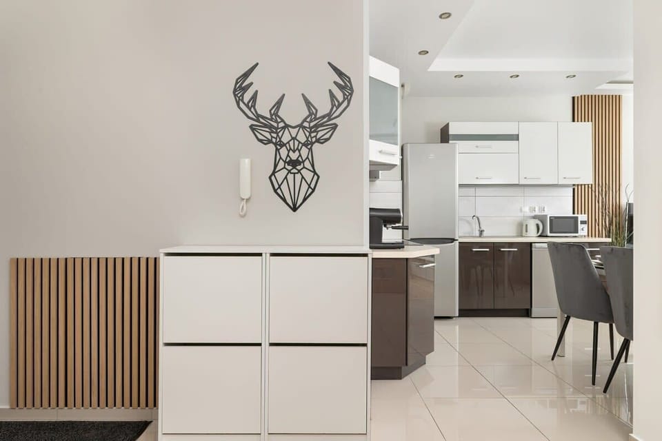 A stylish hallway with modern décor and a unique wall-mounted deer head decoration.

