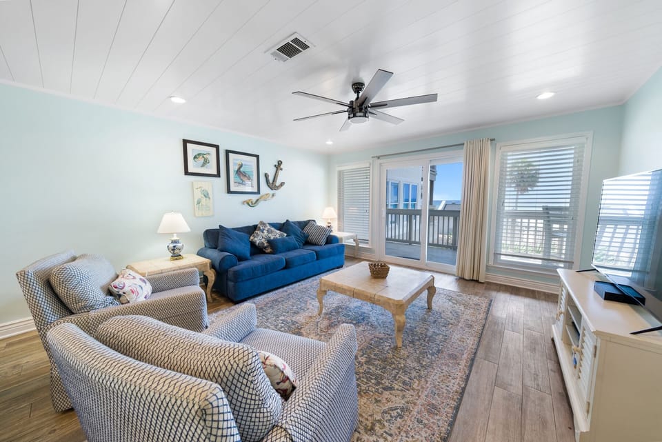 Relax in your coastal living room with plush seating, nautical touches, and peaceful balcony views that invite you to unwind.