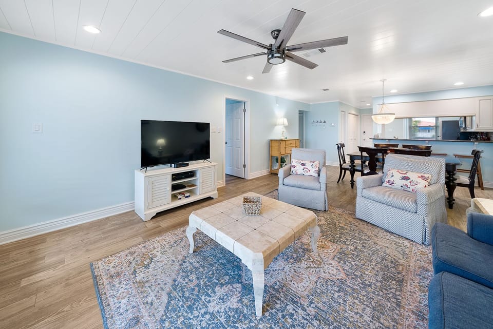 Relax in your bright, open living space with coastal blue accents, comfy seating, and modern amenities for the perfect home-away-from-home feel.
