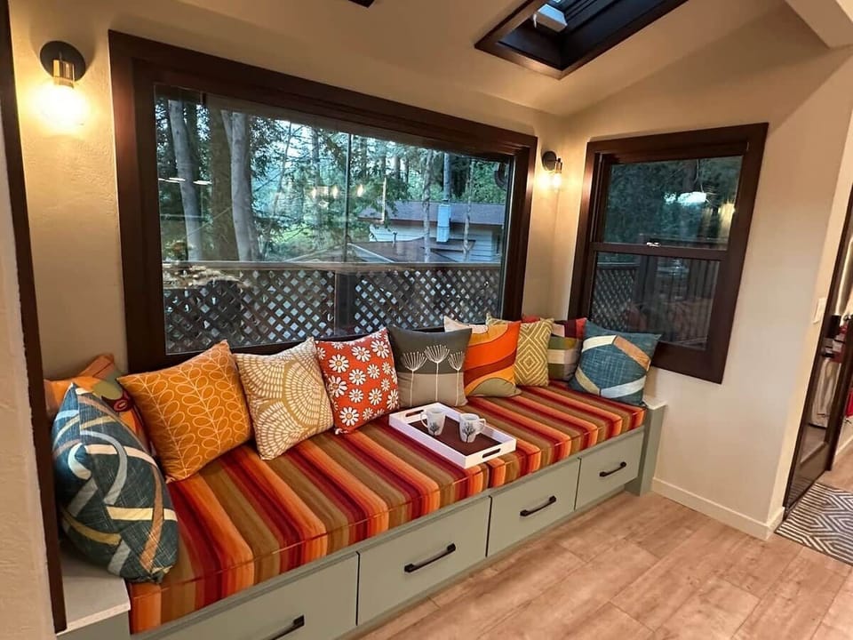 The entry to the kitchen/dining area features a double-sized custom window bench with valley views. A favorite spot in the house to relax and chat with friends in the open plan kitchen and dining area.