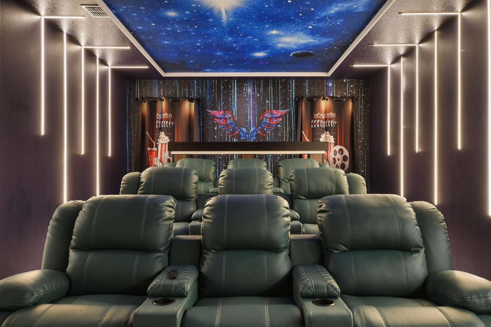 Luxury home theater with reclining seats, starry ceiling, and immersive lighting.