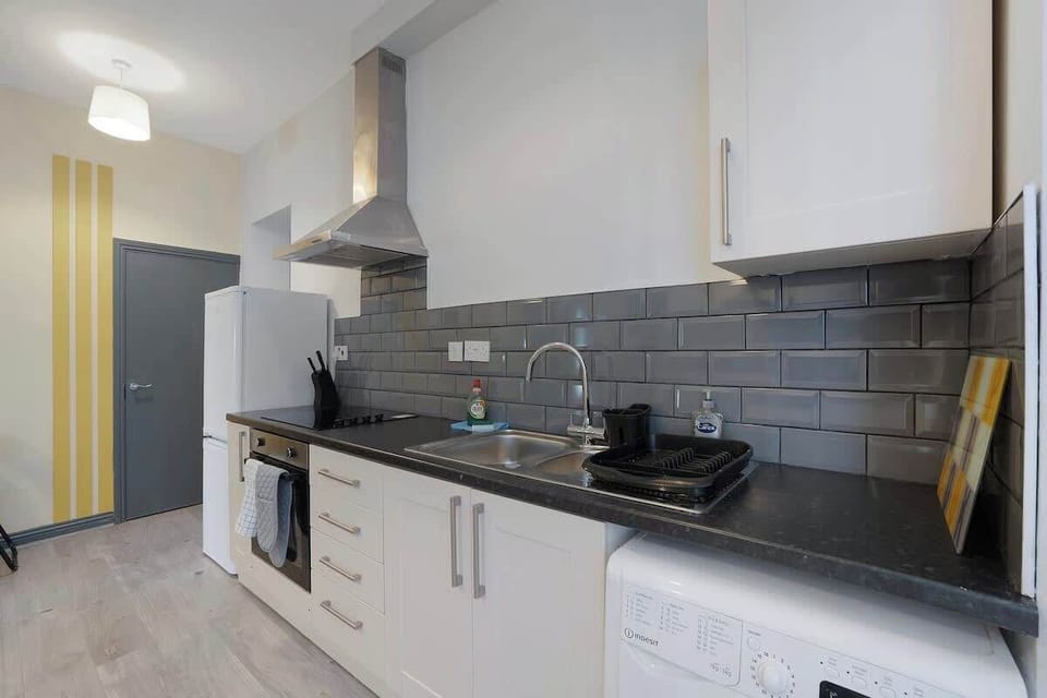 Kitchen equipped with all essentials, including a washer & dryer, oven, fridge and full cookware set.