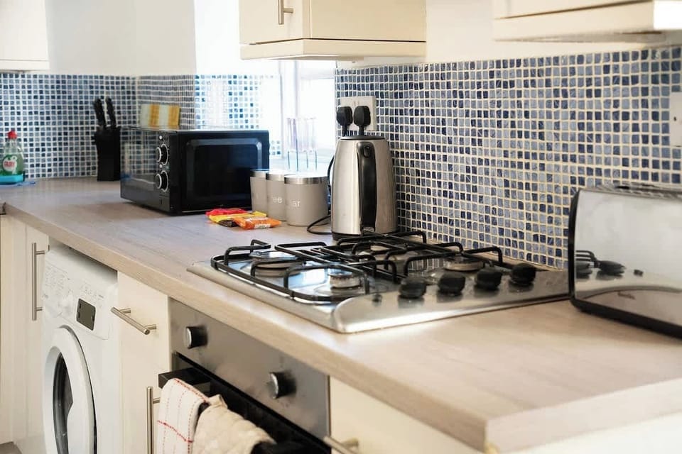 Kitchen equipped with all essentials, including a washer & dryer, oven, fridge and full cookware set.