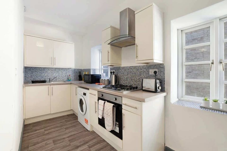 Kitchen equipped with all essentials, including a washer & dryer, oven, fridge and full cookware set.