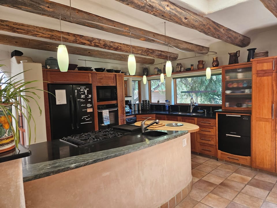 This well designed kitchen has room for 2 cooks. Besides the quality appliances there is a warming oven draw, granite counters, two sink areas, custom cherry cabinets, a breakfast banco and an exterior glass door.