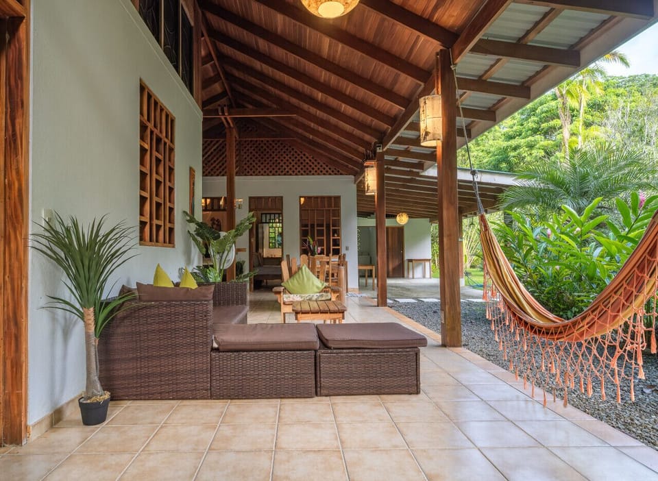 Open-air terrace at Osos Caribeños in Playa Chiquita, featuring tropical lounge spaces and a relaxing hammock surrounded by nature.