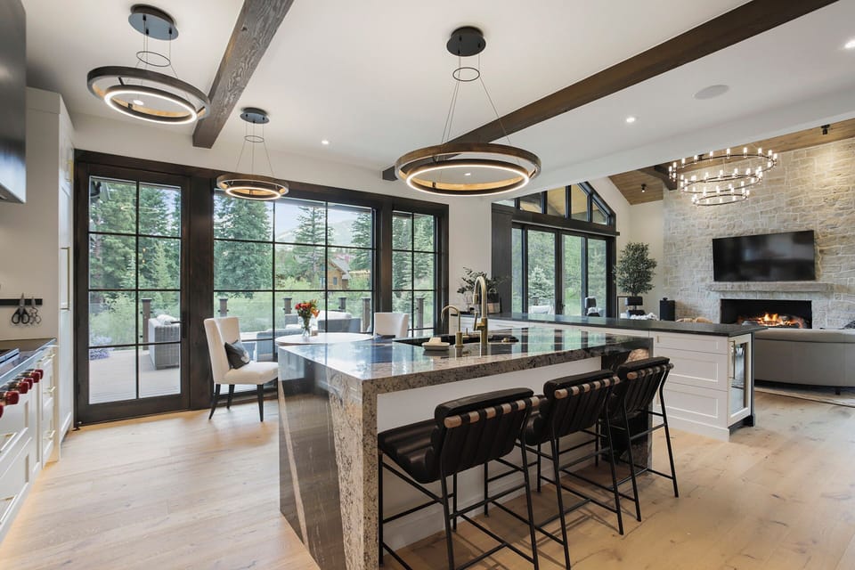 Kitchen opens to back deck and gas grill with ski slopes in the background