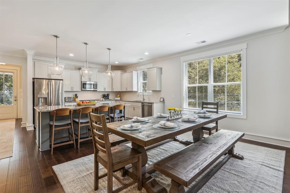 Additional dining area with a farmhouse table for 8 in the living room, plus 4 at the bar
