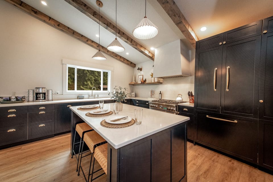 Custom kitchen with large island, gas stove top, custom paneled fridge and dishwasher